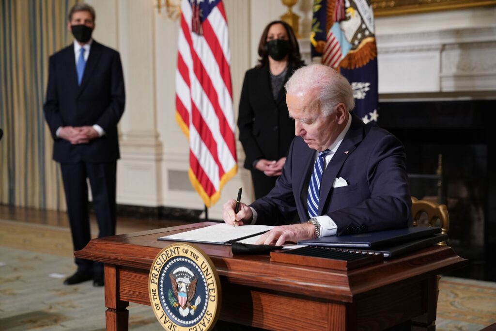 US Vice President Kamala Harris (2-L) and Special Presidential Envoy for Climate John Kerry (L) watch as US President Joe Biden signs executive orders after speaking on tackling climate change, creating jobs, and restoring scientific integrity in the State Dining Room of the White House in Washington, DC on January 27, 2021. (Photo by MANDEL NGAN / AFP) (Photo by MANDEL NGAN/AFP via Getty Images)