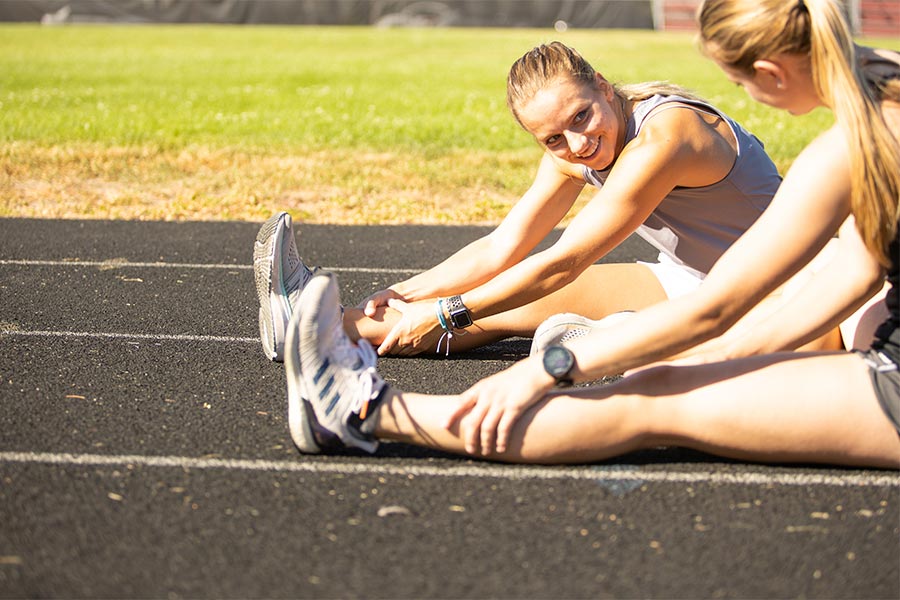 Idaho student athletes Madison Kenyon and Mary Kate Marshall are seen stretching on the track