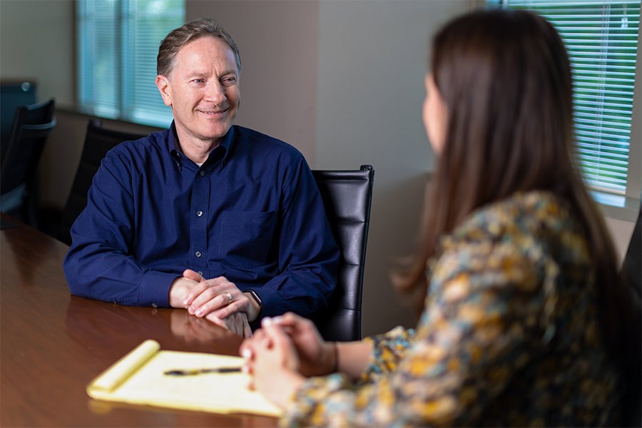 Brian Tingley sits at a conference table having a conversation