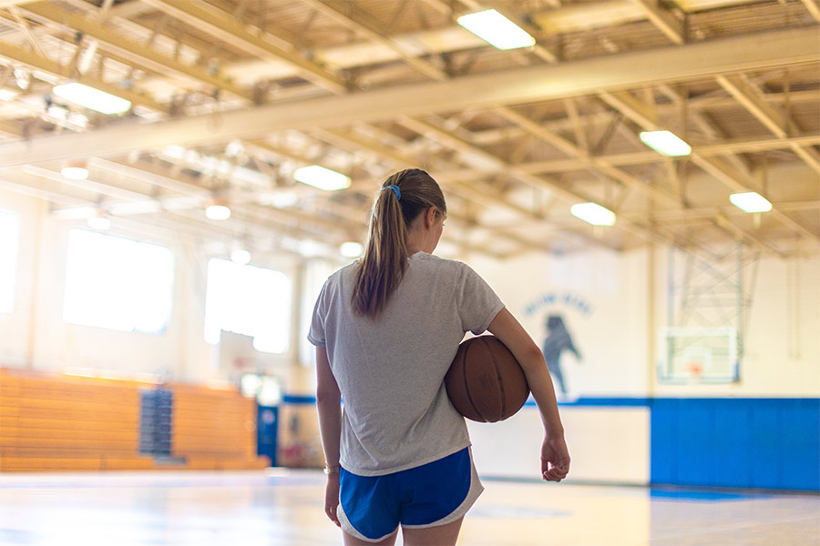 A girl holding a basketball in a Rapides Parish gym