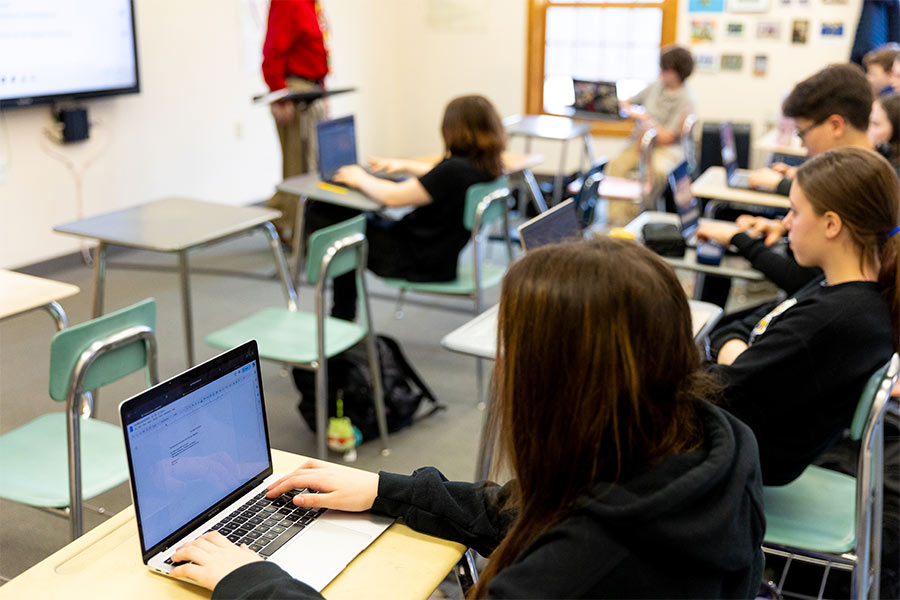 Students at Mid Vermont Christian School sit in a classroom working on their computers