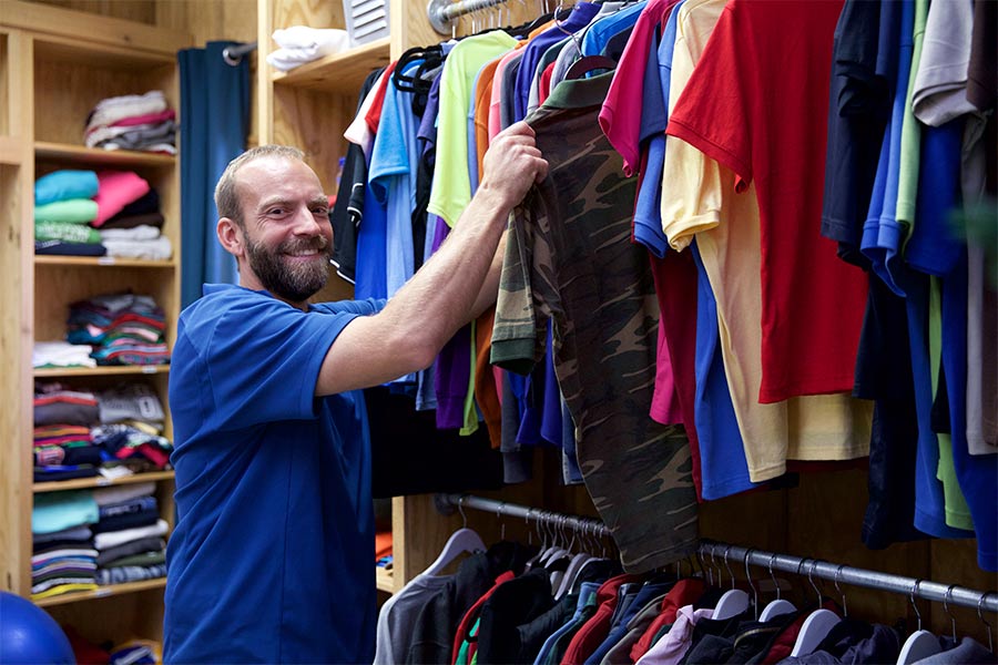 Blaine Adamson reaches for a T-shirt on a rack.